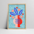 Abstract floral art print with blue leaves and pink vase on a light blue background in a light wood frame