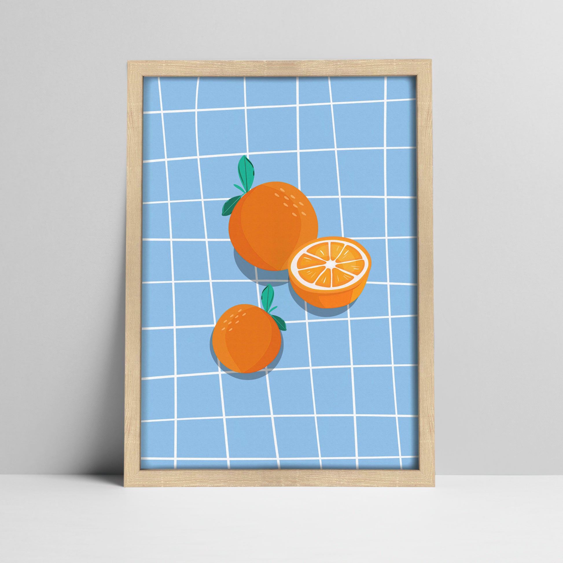 Art print of oranges on blue grid background illustration in a light wood frame