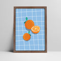 Art print of oranges on blue grid background illustration in a dark wood frame