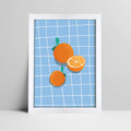 Art print of oranges on blue grid background illustration in a bold white frame