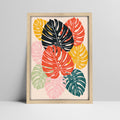 Tropical monstera leaves art print in bold colors in a light wood frame