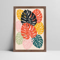 Tropical monstera leaves art print in bold colors in a dark wood frame